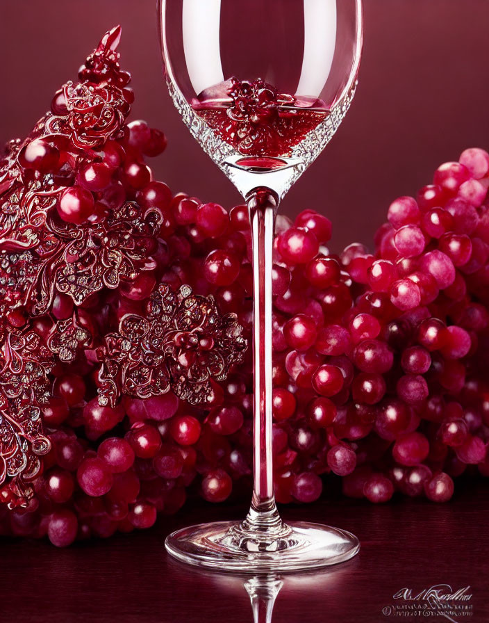 Elegant wine glass with red grapes and grapevine motif on deep red background