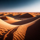 Person and camel crossing desert dunes under clear sky