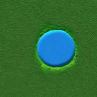 Blue droplet on textured green surface with hexagonal patterns