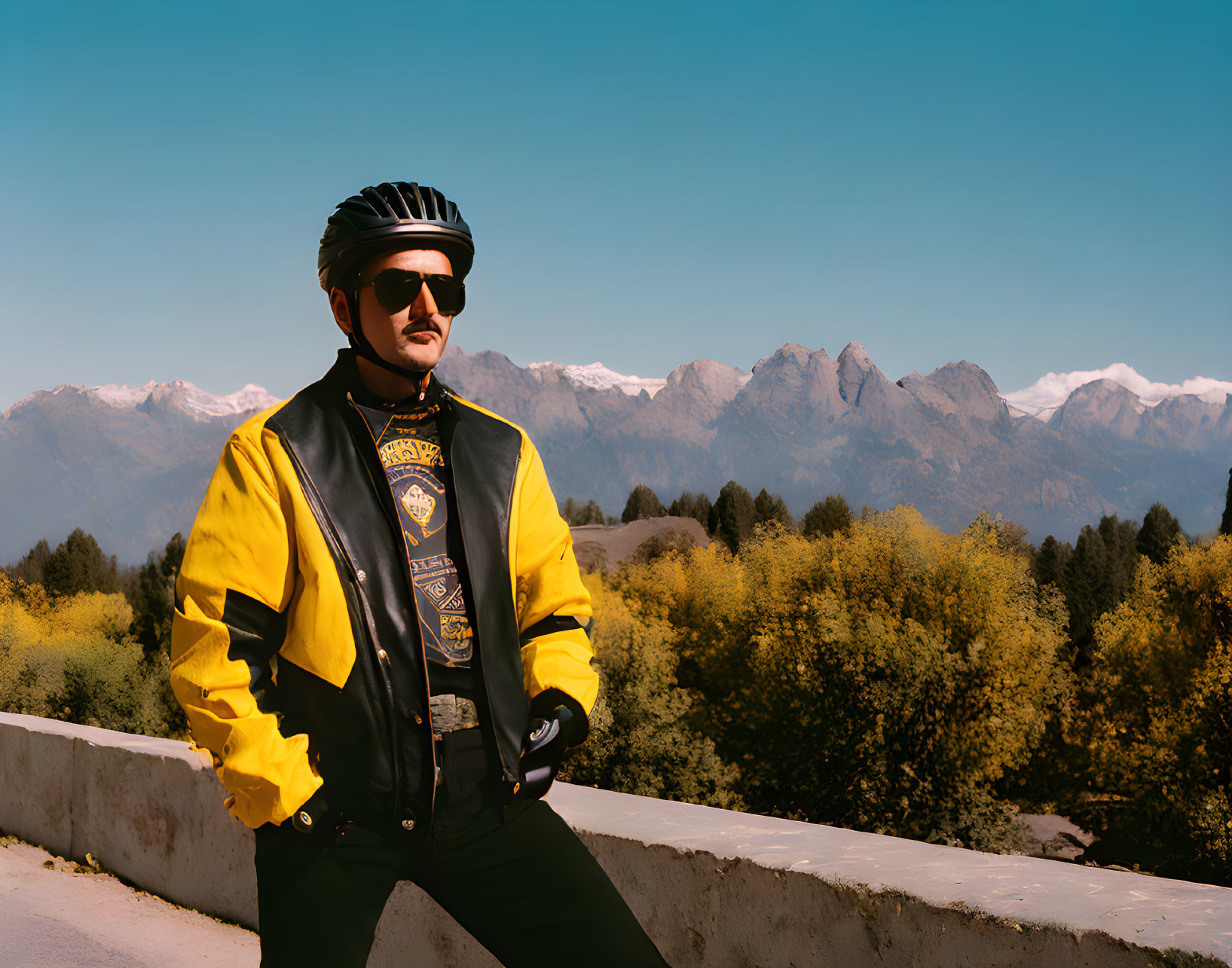 Cyclist in Yellow Jacket by Snow-Capped Mountains