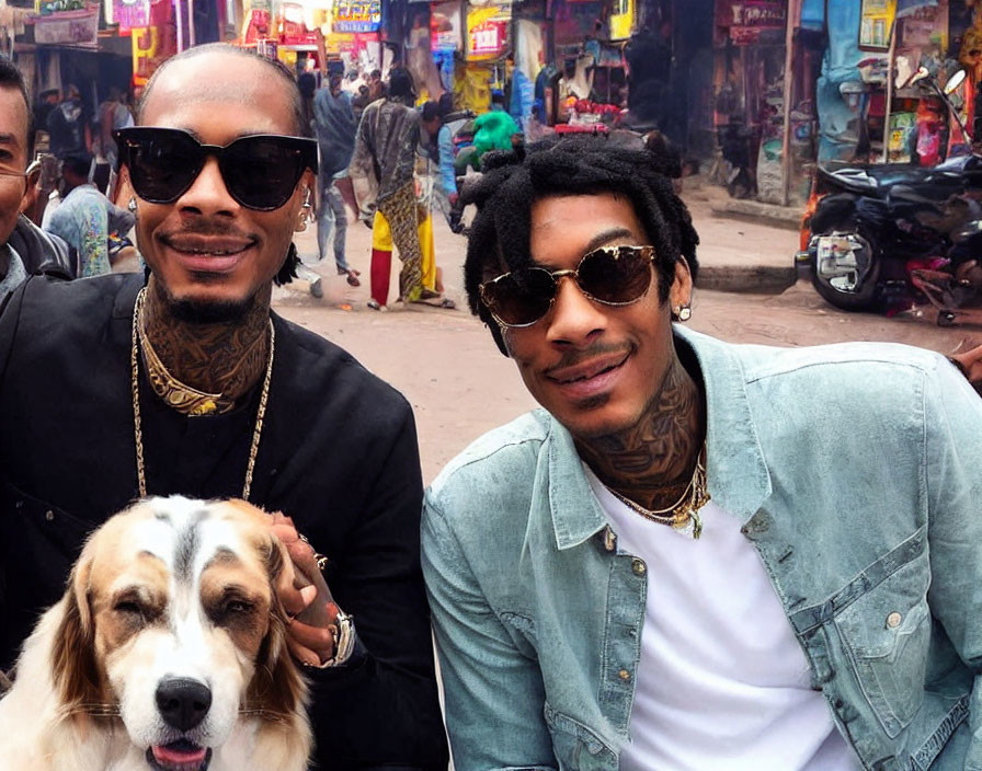 Men posing with a dog on a colorful street.