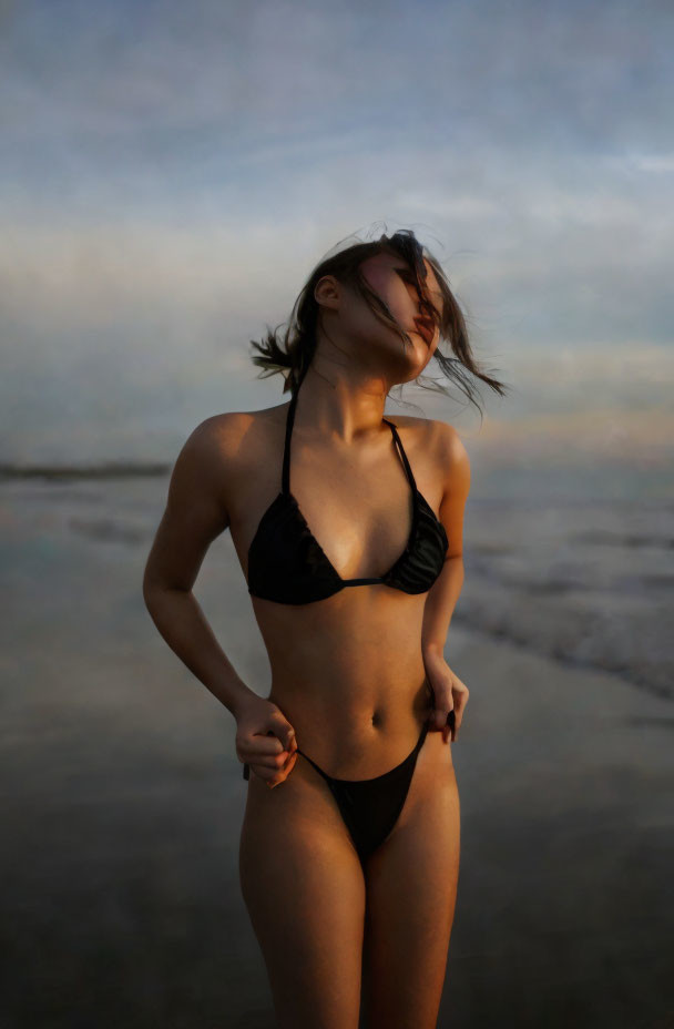 Woman in Black Bikini on Beach with Windblown Hair