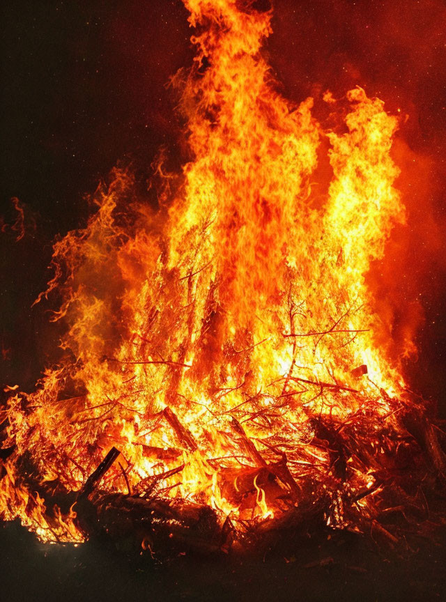 Intense Flames Engulfing Wooden Logs in Large Bonfire