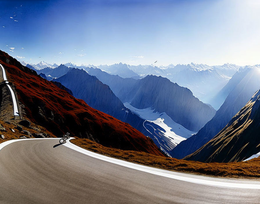 Cyclist on winding mountain road with sharp peaks and deep valleys