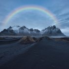 Starry sky and aurora borealis over mountain range with glowing orbs