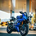 Classic Blue Motorcycle Parked on Concrete with Rustic Wall Background