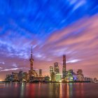 Vibrant cityscape at dusk with misty skyscrapers and birds in silhouette