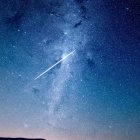 Vibrant Blue and Purple Starry Night Sky with Shooting Stars & Silhouette of Rolling Hills