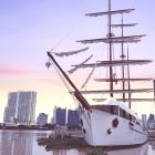 Sailing tall ships on rolling sea waves under pastel sky