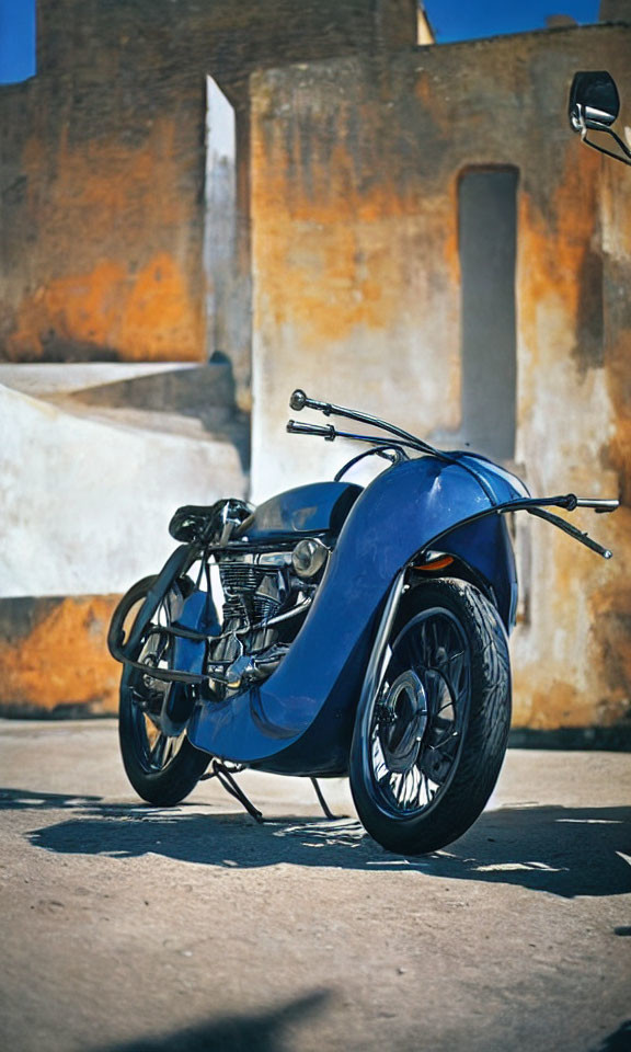 Classic Blue Motorcycle Parked on Concrete with Rustic Wall Background