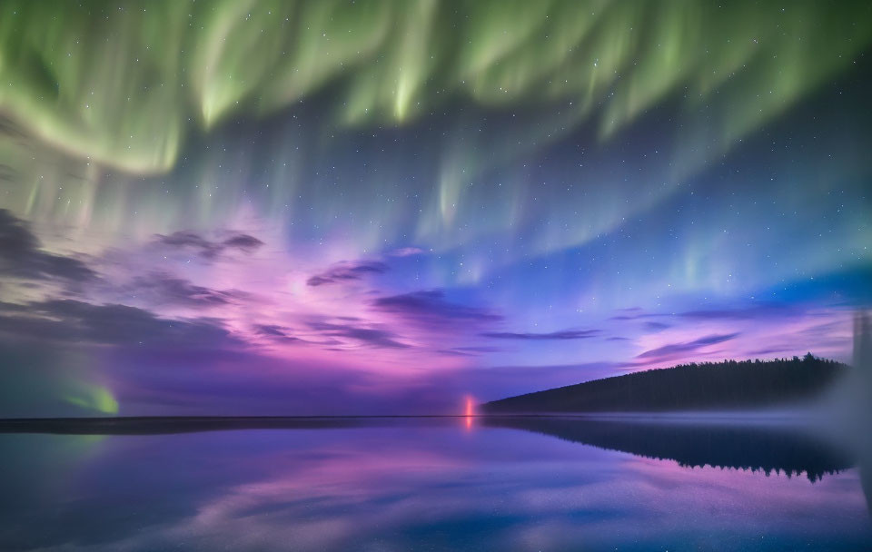 Northern Lights reflected on serene lake with green and purple hues.