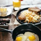 Sunny-Side-Up Eggs, Toast, Orange Juice, Butter on Wooden Table