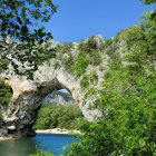 Scenic natural stone bridge over river with lush greenery