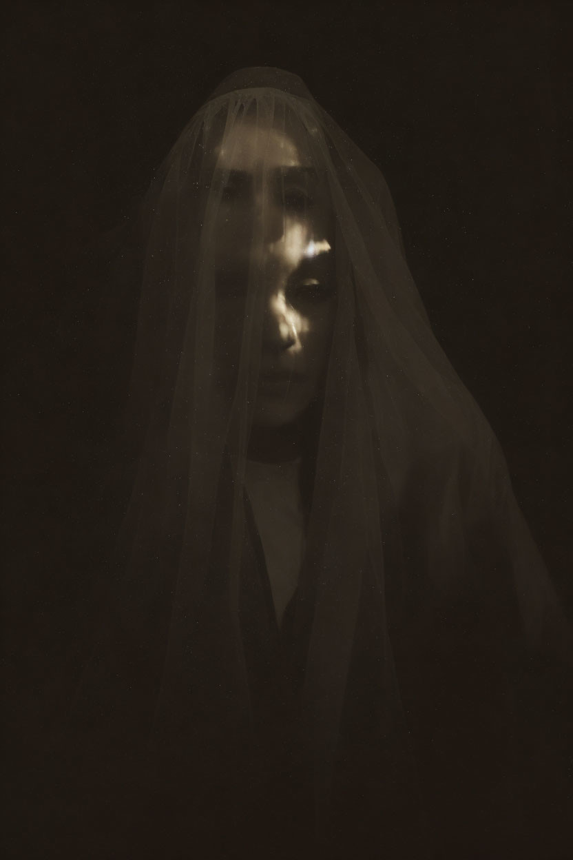 Veiled person with illuminated eyes in spooky image