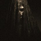 Veiled person with illuminated eyes in spooky image