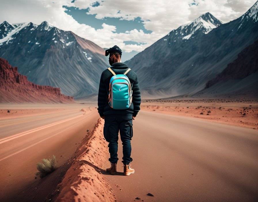 Backpacker admires mountains from desert road