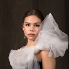 Serene woman in sparkly, bubble-adorned garment on dark background