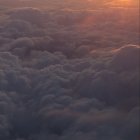 Floating ships above sea of clouds at sunset with vibrant sky