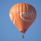 Colorful hot air balloon among others in blue sky with clouds