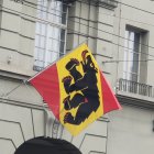 Red and yellow flag with bear silhouette and real bear head below