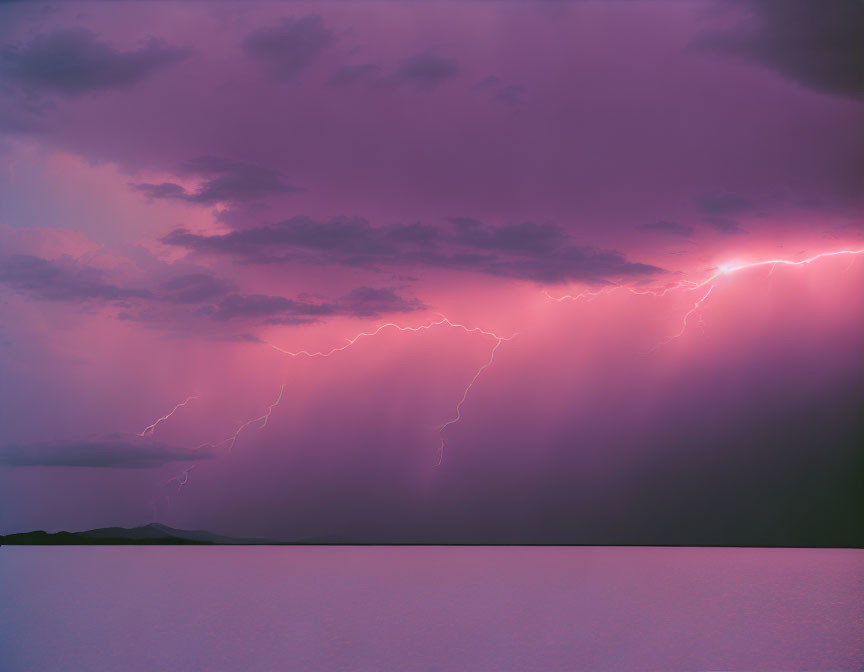 Dramatic purple sky lightning strike over tranquil water