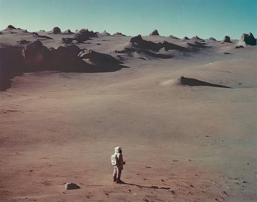 Astronaut in spacesuit on barren rocky landscape