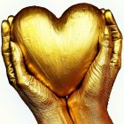 Golden hands hold shiny heart with water droplets
