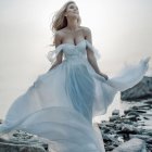 Ethereal woman in white gown amidst ocean waves and soaring bird