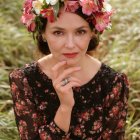 Child with floral crown and petal-adorned outfit in bloom-filled background