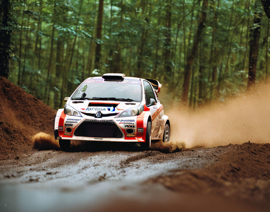 Rally car speeding on dirt track with forest backdrop