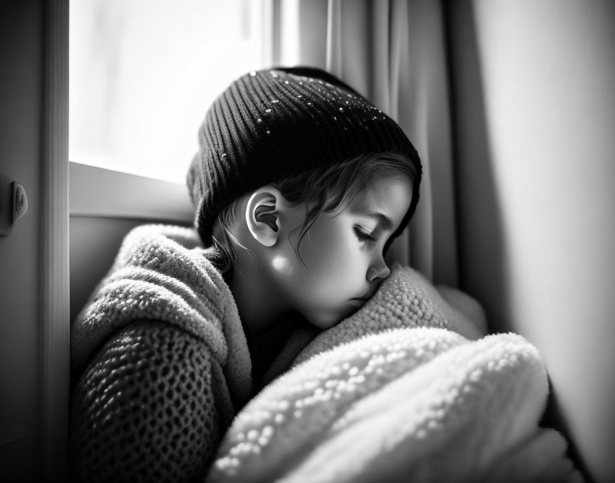 Child in Beanie and Sweater Contemplates Outdoors in Black and White Photo