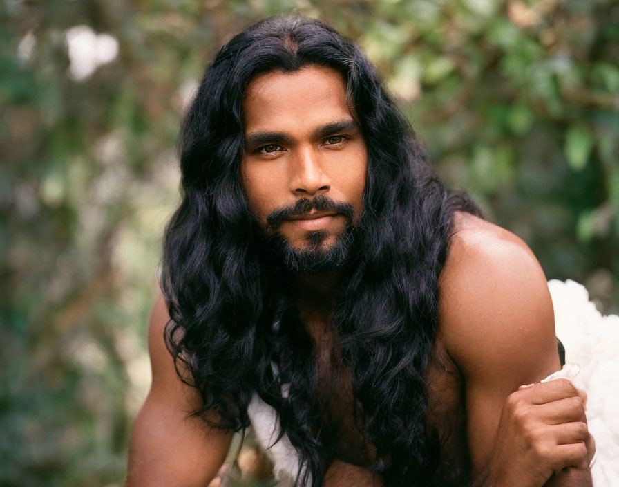 Man with Long Wavy Hair and Beard in White Fabric on Green Background