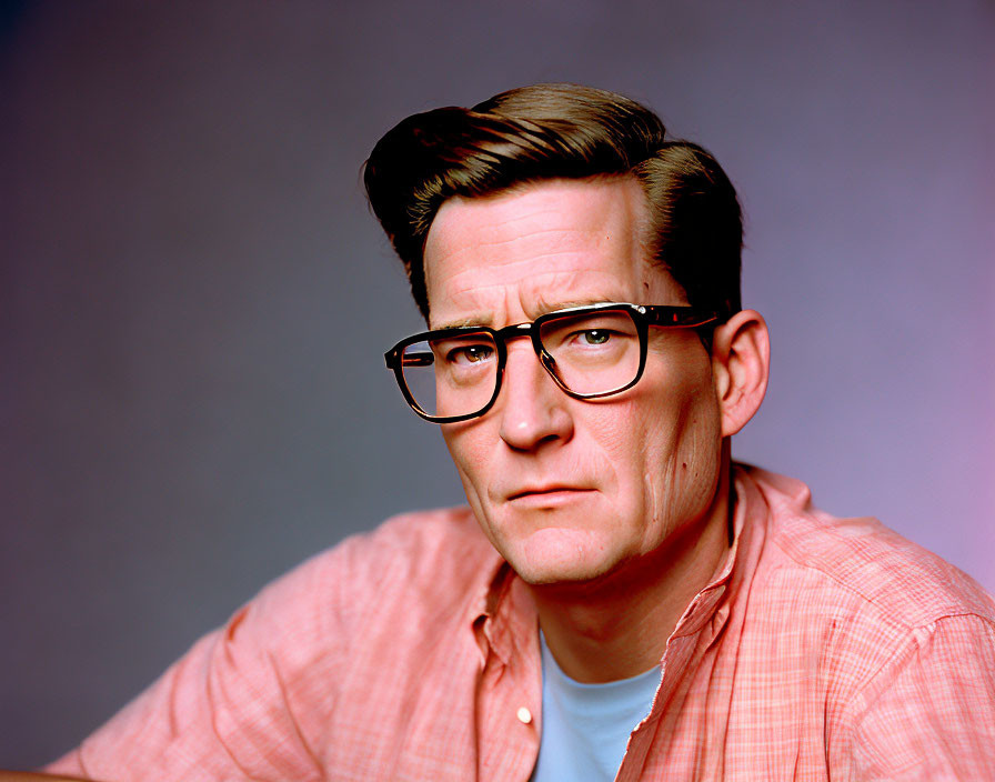 Man in glasses with pink shirt on purple background