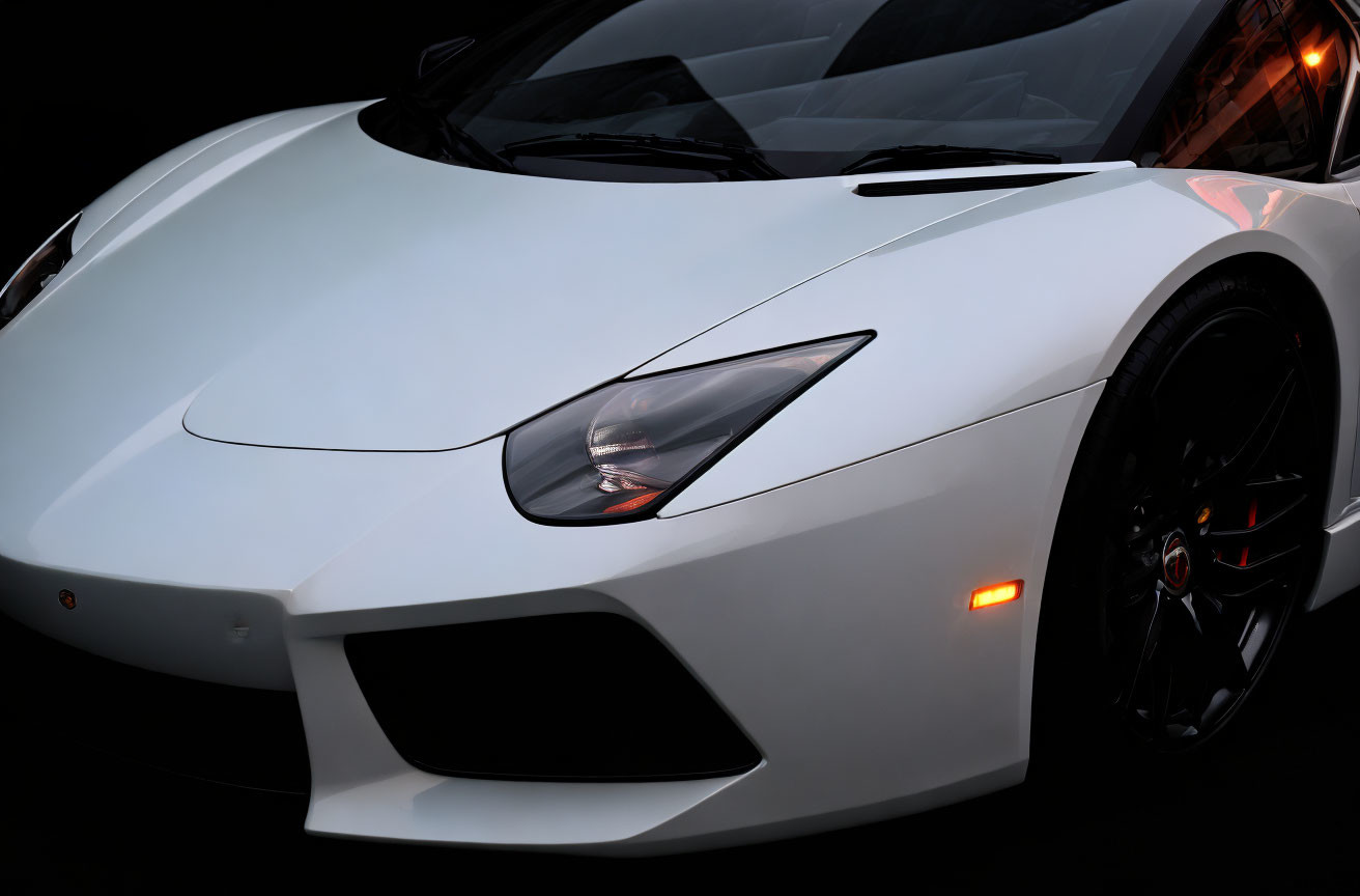 White luxury sports car close-up: angular headlights, sleek lines, and logo on wheel.