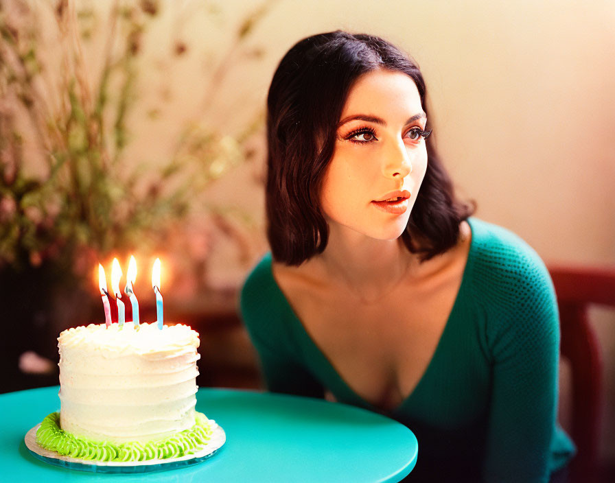 Woman in Green Top with Birthday Cake on Turquoise Table