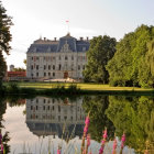 Fairytale castle reflected in calm lake among lush nature