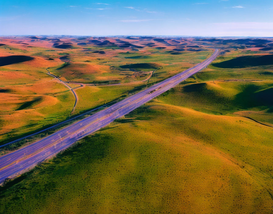 Highway cutting through undulating green hills