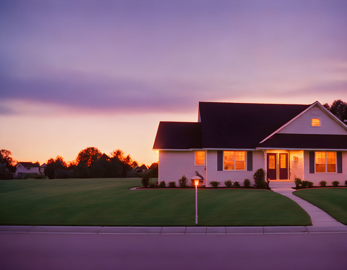 Suburban House with Illuminated Windows at Twilight