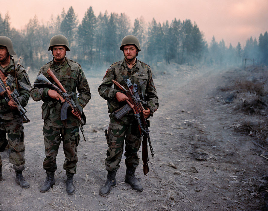 Military soldiers in camouflage uniforms with rifles in forested backdrop