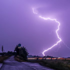 Vivid purple sky lightning storm with bright bolt near road