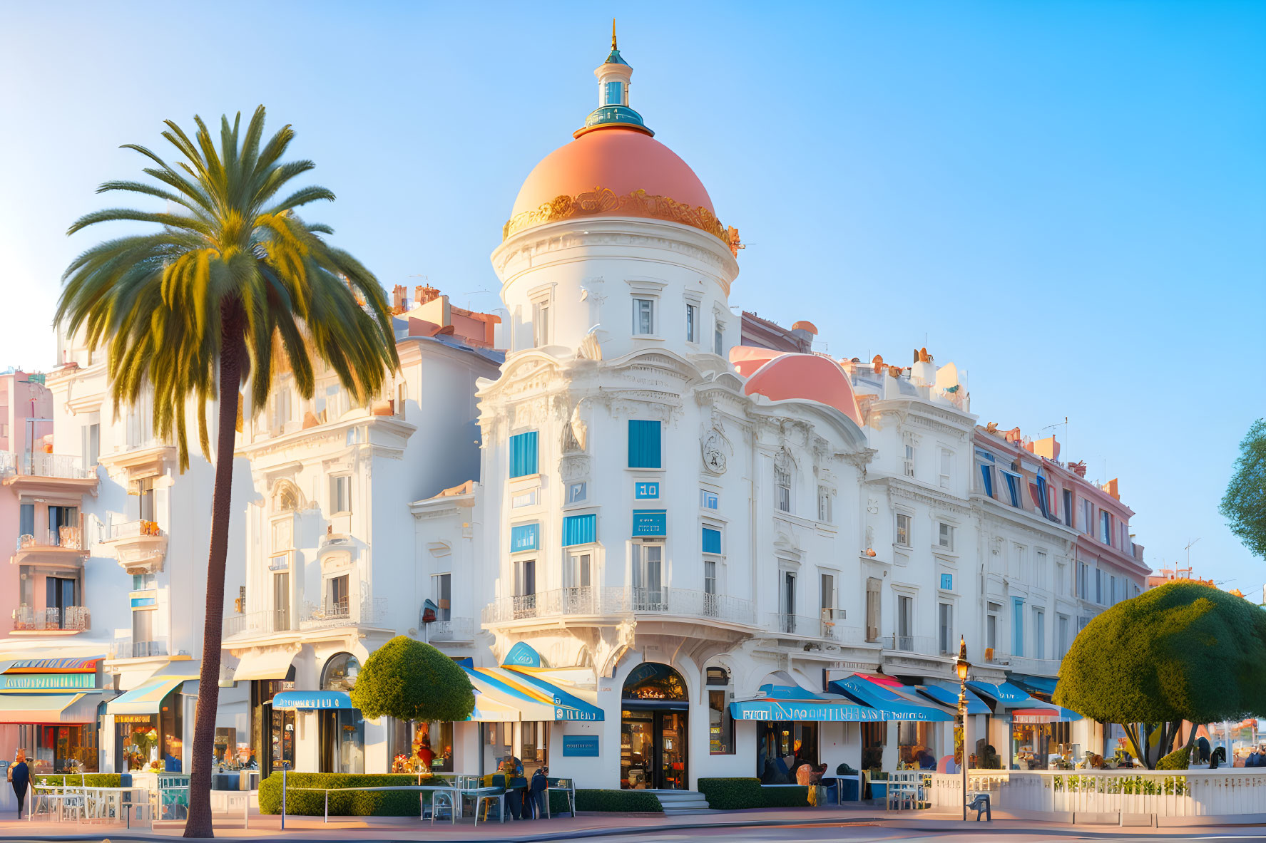 Luxurious coastal hotel with dome, palm trees, and blue sky captured in warm sunlight