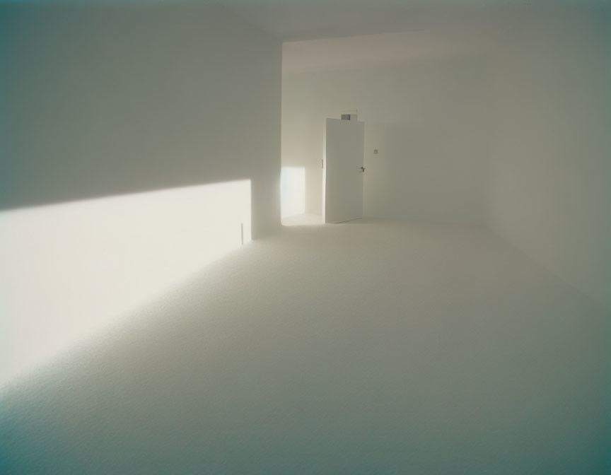 Minimalist Room with Sand-Filled Floor and Partially Open White Door