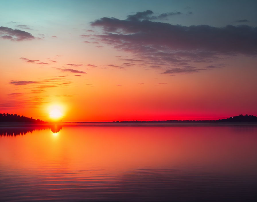 Tranquil sunset over still lake with silhouetted trees and birds in flight