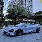 Custom Blue and Black McLaren Sports Car Parked in Front of Modern Building