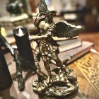 Regal fantasy figure in golden armor with wings and flowers