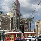 Colorful streetcar and clock tower scene on urban street.