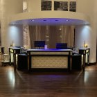 Modern curved reception desk with backlit elements and plants