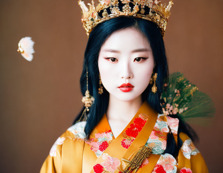 Traditional Asian woman in ornate attire with crown, fan, and butterfly.