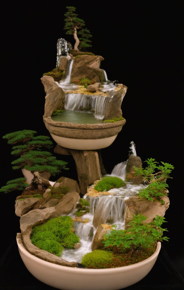 Miniature waterfall landscape with cascades, moss, rocks, and small trees