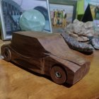 Vintage wooden toy car with globes and ropes on table